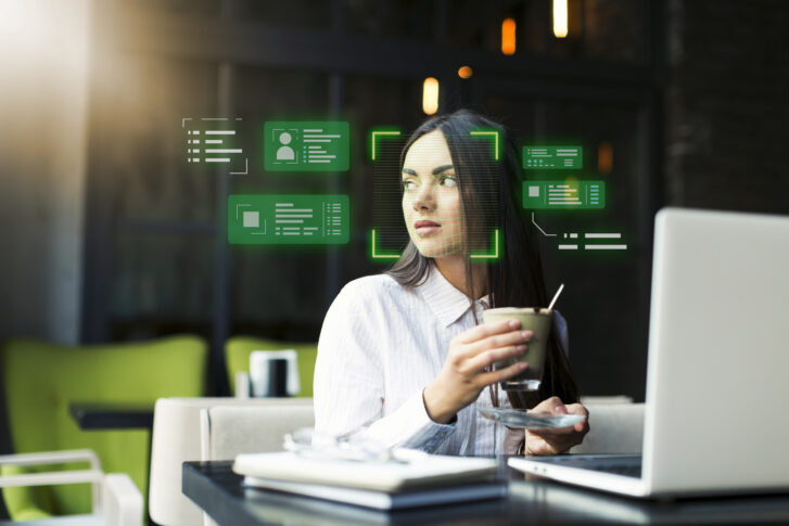 Businesswoman working on a laptop with core HR software interface displaying employee data