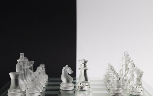Transparent chess pieces facing off on a board, symbolizing Gusto vs ADP comparison