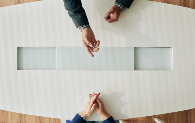 HR professional conducting an employee exit interview across a desk, illustrating how companies use exit interview questions to gather honest feedback before an employee leaves.