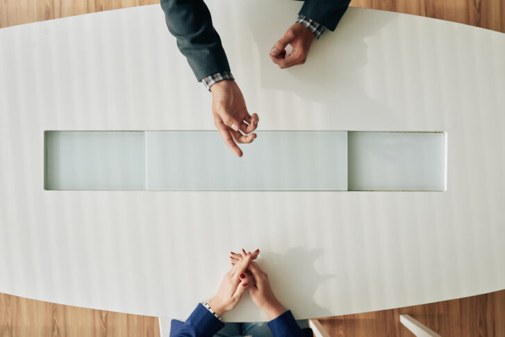 HR professional conducting an employee exit interview across a desk, illustrating how companies use exit interview questions to gather honest feedback before an employee leaves.