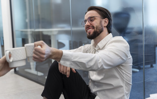 Employee onboarding moment with new hire enjoying coffee in a modern office environment