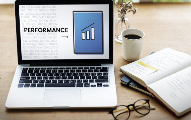 A laptop on a desk displaying a performance chart, representing performance review examples and employee evaluation tools used by HR teams.