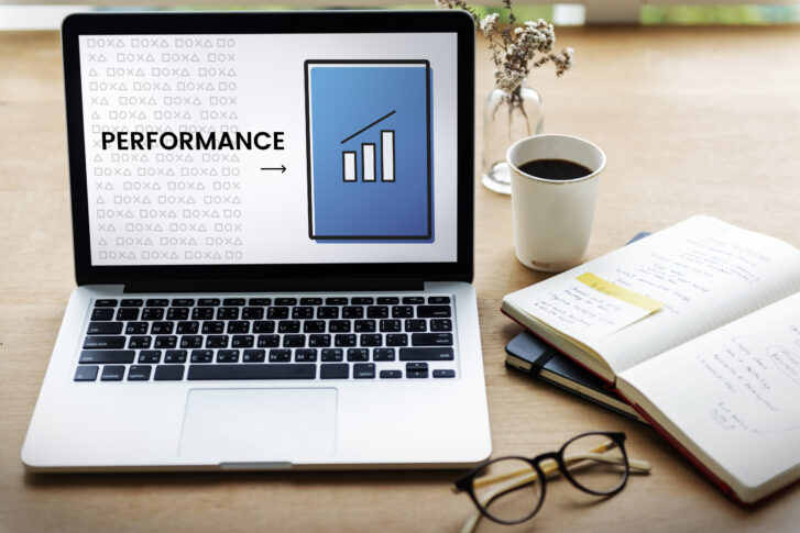 A laptop on a desk displaying a performance chart, representing performance review examples and employee evaluation tools used by HR teams.
